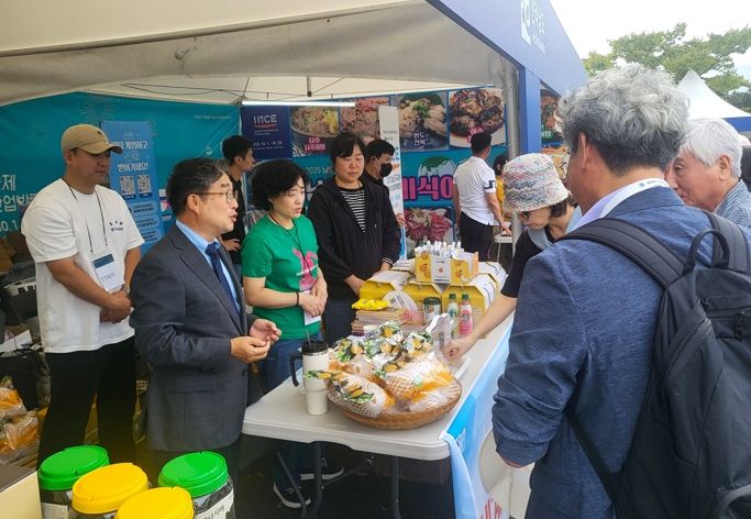 강상구 나주시 부시장(왼쪽)이 나주배 홍보관을 찾은 방문객들에게 시식을 권유하며 나주배 홍보에 열을 올리고 있다.